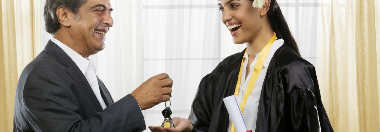 Dad handing graduating daughter keys to car