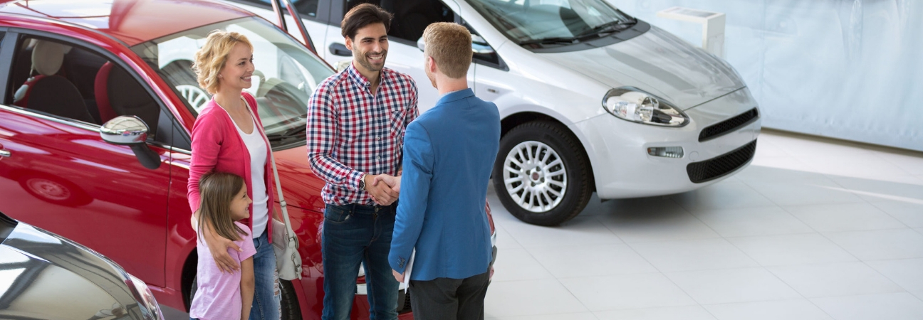 family shaking sales persons hand